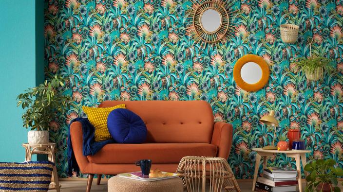 colourful living room with orange sofa and leaf motive wallpaper in orang/green/turqoise