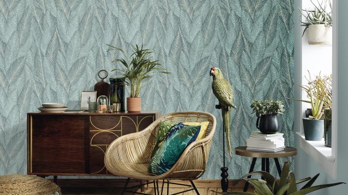 chair and sideboard in front of green leaf wallpaper