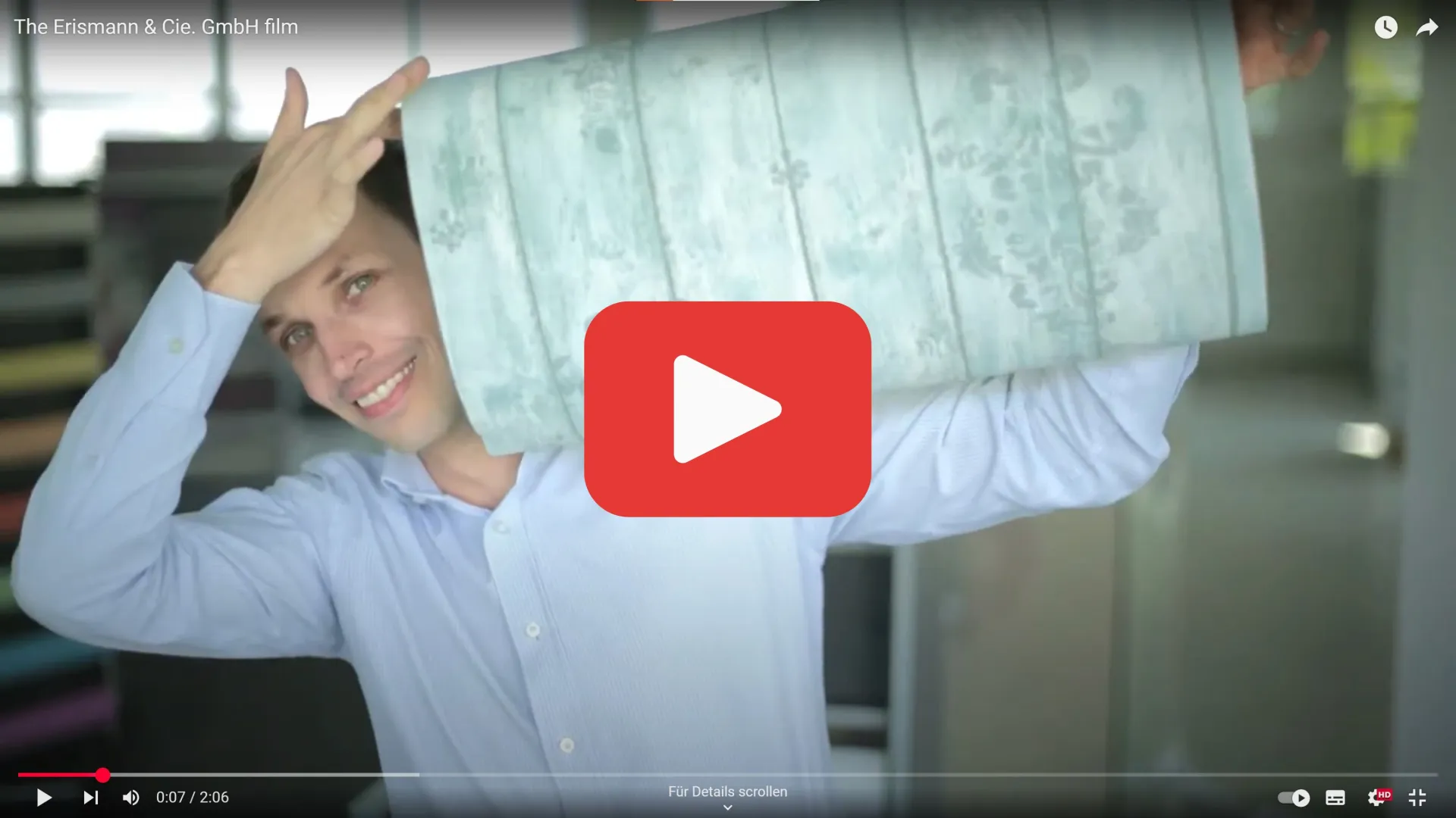 a collegue holding up a roll of wallpaper